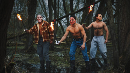 De Wouden scenefoto: mannen met maskers en fakkels in een bos.