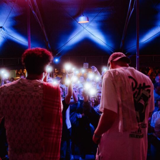 Scenefoto Op een beetje geluk met twee jongens in een popzaal met publiek