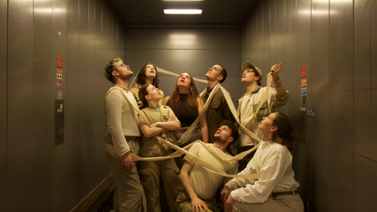 Road to Nowhere ArtEZ foto met 8 jonge mensen in een lift met witte kleding aan verbonden door een lint