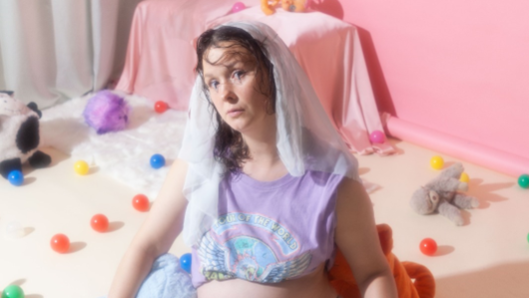 Campagnebeeld Kaatje Kooij’s Stand-Up Show: De Musical met zwangere vrouw zittend in kinderkamer