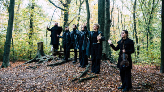 Requiem - zangers en muzikanten op een heuvel in het bos