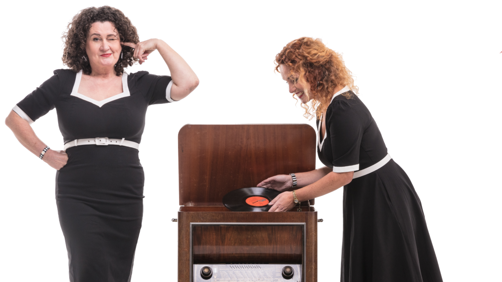 de meisjes van de radio; foto van twee vrouwen in jaren 50 kleding bij een vintage radio