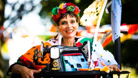 Fiesta - vrolijke vrouw vol bloemen met een ouderwetse naaimachine