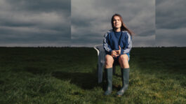 Campagnebeeld van de de voorstelling Flatland. Je ziet isabel schoonbeek op stoel zitten midden in een weiland.