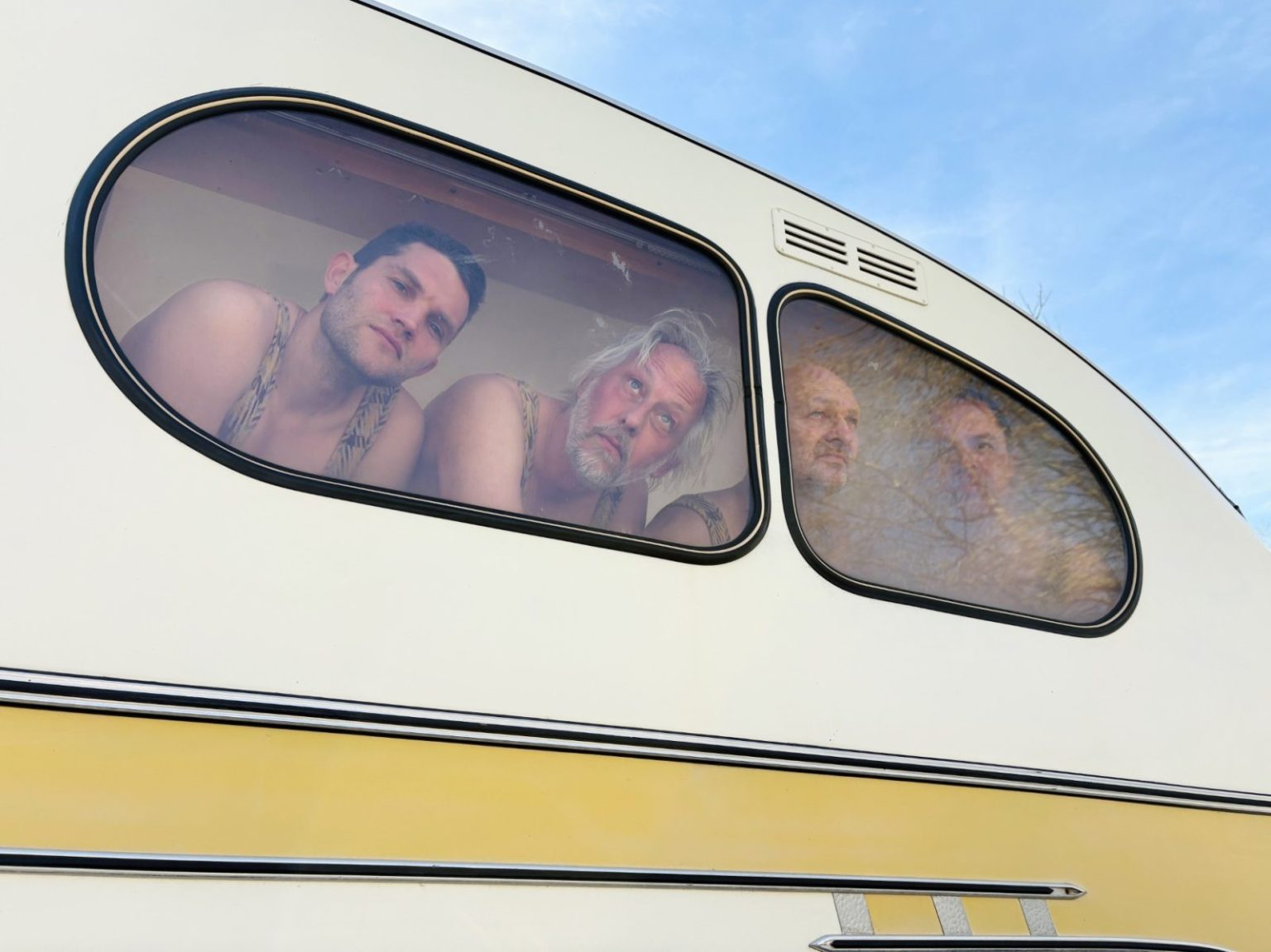 WAAN van BOT - 4 mannen in hemd achter het raam van een kleine caravan