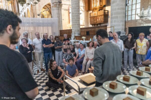 diverse mensen in een kerk rondom een man met handen van chocolade